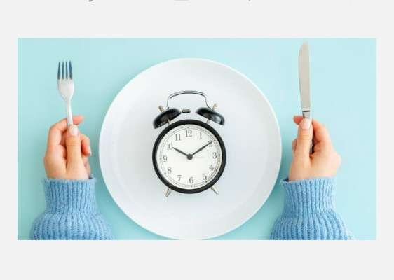 DIAGRAM OF A PERSON'S ARMS AT A LIGHT BLUE TABLE WITH A FORK IN ONE HAND AND A KNIFE IN THE OTHER WITH A CLOCK ON THE WHITE PLATE