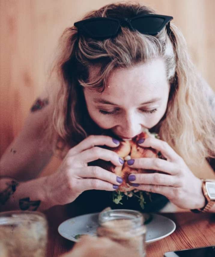 YOUNG LADY SITTING AT TABLE- BINGE EATING