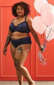 PLUS SIZE MODEL WEARING BLACK 2-PIECE UNDERWEAR OUTFIT HOLDING PINK BALLOONS