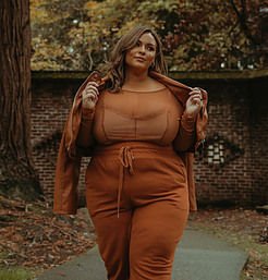 DIET TIPS FOR WOMEN OVER 50 = OLDER WOMAN WEARING A RUST COLOR PANTS SUIT WITH SEE THROUGH RUST CAMIE