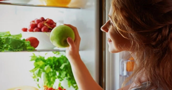 EASY TIPS TO LOSE WEIGHT - LADY PACKING HER FRIDGE WITH FRESH FRUITS AND VEGGIES