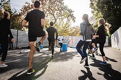 How to Lower Cortisol Levels - Group of people taking exercise class outdoors on a sunny day