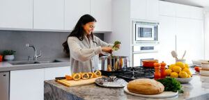 WOMAN IN HER KITCHEN PREPARING HEALTHY FOODS FOR HER FAMILY