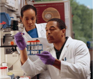 GENETICS AND BURNOUT. TWO RESEARCHERS AT WORK IN THEIR LABORATORY  TO STUDY GENETICS AND EMOTIONAL BUROUT. THEY ARE WEARING WHITE JACKETS as they test genes