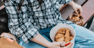 CUSTOMER EATING A BUCKET OF KFC CHICKEN