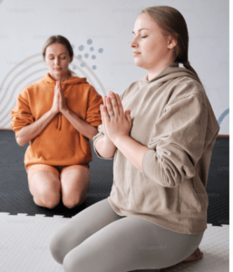 TWO YOUNG SISTERS DOING MEDITATION ON THE FLOOR