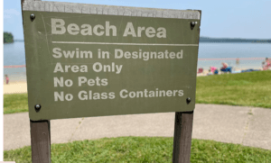 WARNING SIGN AT THE BEACH TO SWIM IN DESIGNATED AREA