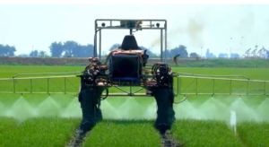 TWO WORKERS IN GARDENING GEAR WORKING THE HARMFUL PESTICIDE MACHINE