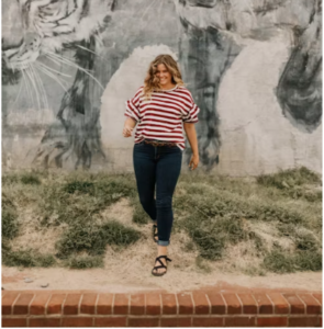 PLUS SIZE MODEL WEARING A RED AND WHITE STRIPE TOP WITH HER BLUE JEANS