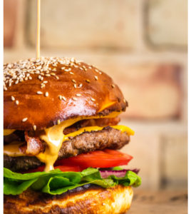 A BIG JUICY PLANT-BASED BURGER WITH LETTUCE, TOMATOES AND CHEESE ON A CRISP SESAME SEED BUN