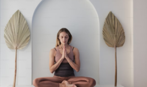 WOMEN IN A YOGA SET IN A YOGA POSE DOING MINDFULNESS YOGA