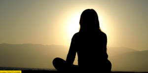 SILHOUETTE OF A WOMAN DOING MINDFULNESS YOGA PRACTICES