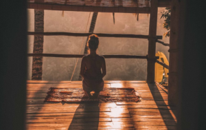 LADY ON A WOODEN FLOOR IN YOGA POSITION GEARING UP FOR A MIRACLE IN MINDFULNESS PRACTICES